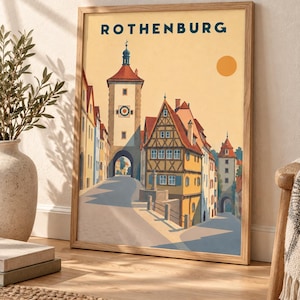 以下が含まれることがあります： 上部に「ROTHENBURG」の文字が記された、ローテンブルクの様式化されたイラストの額入りアートプリント。木組みの建物、高い時計塔、そして丸いオレンジ色の太陽が浮かぶ黄色い空が描かれた街並みの風景が表現されています。