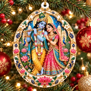 May include: An oval-shaped Christmas ornament featuring a detailed illustration of Krishna playing a flute alongside Radha. The figures are adorned in vibrant traditional attire, surrounded by lotus flowers, peacocks, and a palace backdrop, all encased in an ornate, cream-colored frame with gold and blue accents.