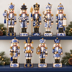 Può includere: Una collezione di nove statuette schiaccianoci con motivi in stile porcellana blu e bianca. Ogni figura indossa un'uniforme dettagliata con accenti dorati e tiene in mano vari oggetti come lanterne, ventagli, pergamene, gabbie e vasi.