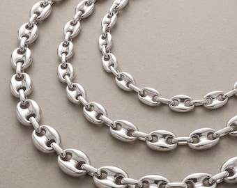 Può includere: Una collana a catena color argento con maglie ovali, arrotondate e lucide, collegate in un motivo continuo. Le maglie metalliche hanno una superficie liscia e riflettente e sono disposte in diversi anelli circolari sovrapposti.