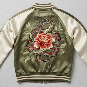 May include: An olive green satin bomber jacket featuring a large, detailed embroidery on the back. The design depicts a coiled snake with red, black, and white scales surrounding a vibrant red and orange peony flower with green leaves.