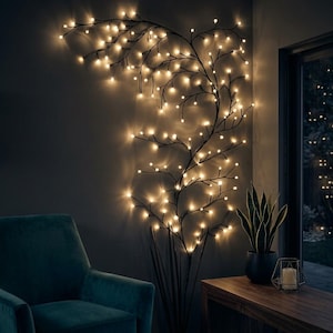May include: A wall-mounted decorative branch light fixture featuring a dark, slender frame with numerous small, warm white LED bulbs attached to the tips of the branches, creating a glowing, tree-like silhouette against the wall surface.