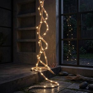 Può includere: Una spessa corda luminosa color naturale caratterizzata da un design a spirale intrecciata che si estende verticalmente. La corda è dotata di piccole luci LED dai toni caldi che emettono una luce soffusa, creando un percorso illuminato.