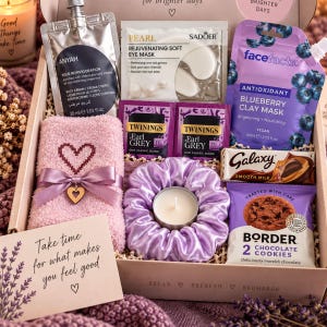 May include: A gift box containing a pink fuzzy towel with a heart, a lavender satin scrunchie with a tea light, Anyah body cream, Sadoer eye mask, Face Facts blueberry clay mask, two Twinings Earl Grey tea bags, a Galaxy chocolate bar, and Border cookies.
