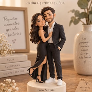 Puede incluir: Una figura 3D personalizada de una pareja sobre una base circular con la inscripción "Sara & Luis 14.06.2026". La figura muestra a una persona con cabello largo oscuro en vestido negro y a otra con cabello corto en traje oscuro.