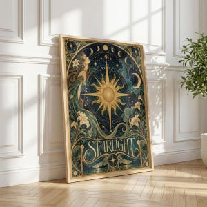 May include: A rectangular framed wall art print featuring a central golden sunburst, a profile of a person, and white lily flowers against a dark blue celestial background with moon phases and stars. The word STARLIGHT is printed in gold lettering.