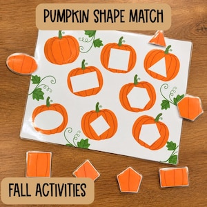 May include: A laminated educational activity sheet titled PUMPKIN SHAPE MATCH featuring eight orange pumpkin illustrations with various white geometric cutouts. Includes eight matching orange pumpkin-shaped pieces with corresponding shapes.