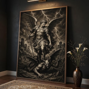 Op de afbeelding: Een ingelijste muurkunstprint in zwart-wit tinten met een gevleugelde figuur in harnas die een speer vasthoudt terwijl deze boven een gehoornde demon staat. De achtergrond toont een stormachtige lucht met bliksemschichten en stenen ruïnes.