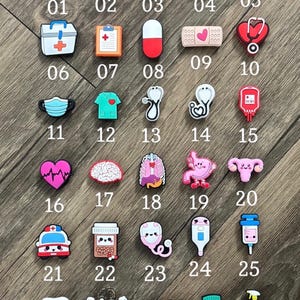 May include: A collection of thirty medical-themed shoe charms arranged in a grid, labeled with numbers 01 through 30. The charms feature colorful designs including a caduceus, heart, cross, stethoscope, pill, bandage, mask, organs, and medical equipment.