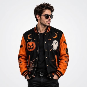 Puede incluir: Una chaqueta universitaria negra y naranja con motivos de Halloween bordados, incluyendo una calabaza, un fantasma, lunas crecientes, murciélagos y telarañas. La chaqueta tiene mangas naranjas, cuerpo de lana negra y bordes acanalados.