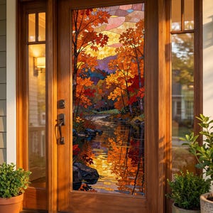 May include: A wooden front door with a large stained glass panel featuring an autumn forest landscape with orange, red, and yellow maple trees reflecting in a calm river. The door has a dark metal handle and a deadbolt lock mechanism.