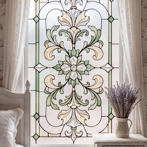Puede incluir: Una película rectangular para ventana con un diseño simétrico de vidriera que presenta paneles texturizados en color crema, verde salvia y transparente. El patrón consta de motivos florales centrales, hojas de acanto y bordes geométricos.