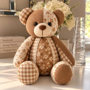 Pu&ograve; includere: Un orsacchiotto di peluche realizzato con vari pezzi di tessuto, tra cui quadretti marroni, lino marrone tinta unita e tessuto color crema con un motivo floreale marrone. L'orso presenta un muso color crema, occhi a bottone neri e pizzo.