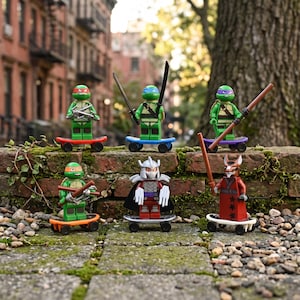 May include: Six Teenage Mutant Ninja Turtles themed minifigures on individual skateboards. The figures include four turtles with colored masks, Shredder in silver armor, and Master Splinter in a red robe, each holding their signature plastic weapons.