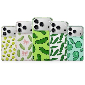 Puede incluir: Cinco fundas para smartphone dispuestas en fila, cada una con un patrón distinto. Los diseños incluyen rodajas de pepinillo amarillas, pepinillos verdes con lazos rosas, pepinillos enteros sobre fondo verde lima, blanco y pepinos en rodajas.