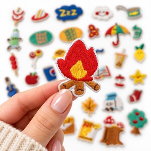 May include: An embroidered campfire patch featuring a bright red flame with a yellow center and brown logs at the base. The patch is surrounded by a variety of other small, colorful embroidered patches depicting various objects.