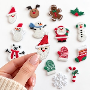 May include: A collection of small embroidered Christmas-themed patches featuring various designs including Santa Claus, snowmen, a gingerbread man, a reindeer, a stocking, mittens, a candy cane, a snowflake, and holly leaves in red, white, and green.