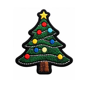 May include: An embroidered patch shaped like a Christmas tree with a brown trunk and green foliage. The tree is decorated with a yellow star at the top, white stitched garland lines, and small circular ornaments in red, blue, and yellow colors.