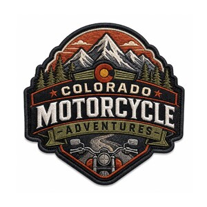 May include: An embroidered patch featuring a mountain landscape with pine trees, a motorcycle handlebar view, and the text COLORADO MOTORCYCLE ADVENTURES. The design uses orange, white, black, and green thread with a circular Colorado state emblem.