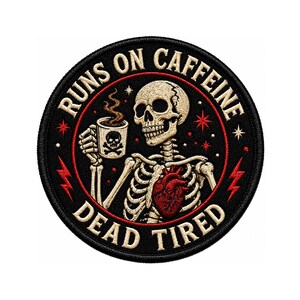Könnte beinhalten: Ein runder gestickter Aufnäher mit schwarzem Hintergrund zeigt ein beiges Skelett, das eine dampfende Kaffeetasse mit Totenkopf-Symbol hält. Ein rotes anatomisches Herz ist auf der Brust zu sehen. Der Text lautet RUNS ON CAFFEINE DEAD TIRED.