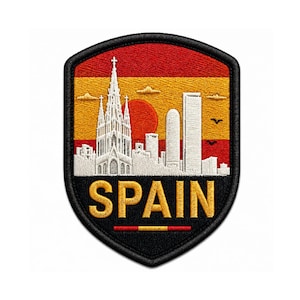 May include: A shield-shaped embroidered patch featuring a skyline of white buildings, including a tall cathedral, set against a background of red and yellow horizontal stripes. The word SPAIN is stitched in gold letters at the bottom.