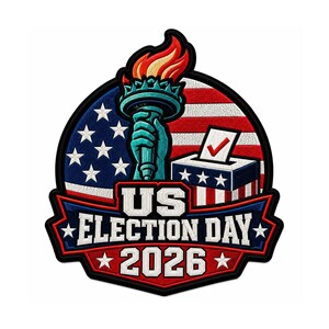 May include: A circular embroidered patch featuring the Statue of Liberty torch, a ballot box with a red checkmark, and the American flag. The text US ELECTION DAY 2026 is displayed in white block letters on a blue and red banner at the bottom.