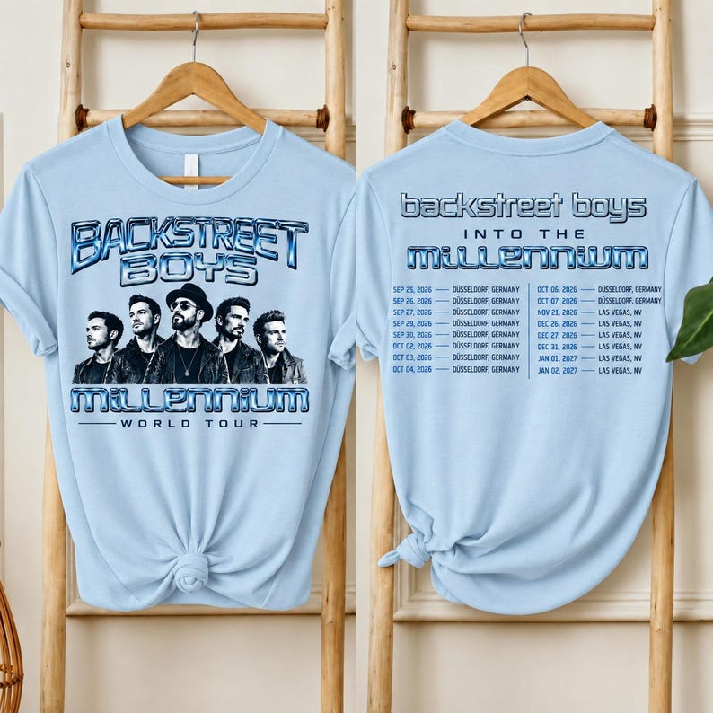 May include: A light blue t-shirt featuring a graphic of the Backstreet Boys on the front with the text Backstreet Boys Millennium World Tour. The back of the shirt displays the text Backstreet Boys Into The Millennium and a list of tour dates.