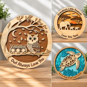 Könnte beinhalten: Drei kreisförmige Wandkunstobjekte aus Holz mit geschichteten Laserschnitt-Designs. Eines zeigt Eulen auf einem Ast mit dem Text Owl Always Love You, ein anderes Elefanten in der Savanne und eines zeigt Meeresschildkröten.