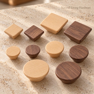 May include: A collection of wooden cabinet knobs in light beech and dark walnut finishes, featuring square and circular shapes. The text Natural Living Hardware is visible in the upper right corner. These knobs have smooth, tapered bases.