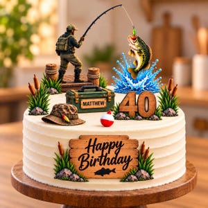 May include: A round cake decorated with a fishing theme, featuring a figurine of a person fishing, a jumping bass, a green tackle box labeled 'MATTHEW', a brown hat, a red and white bobber, and the number '40'. A wooden sign reads 'Happy Birthday'.