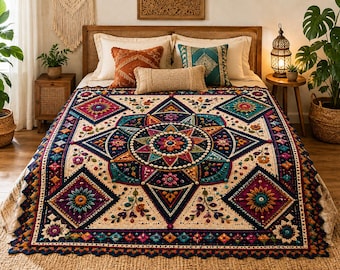 May include: A large, rectangular crochet blanket featuring a complex, symmetrical mandala pattern in deep navy, magenta, teal, and cream. The design includes raised floral motifs, textured bobble stitches, and a scalloped edge border.