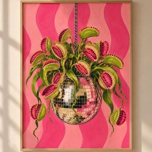 May include: A framed wall art print featuring a silver disco ball hanging from a chain, serving as a planter for multiple green and pink Venus flytrap plants. The background consists of vertical wavy stripes in two shades of pink.