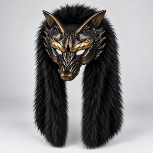 Peut inclure: Un masque de loup avec une finition bronze métallique et noire, doté d'oreilles pointues et de traits faciaux marqués. Le masque est encadré par une longue et épaisse fausse fourrure noire qui descend sur les côtés, formant une crinière texturée.