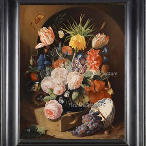 May include: A still life painting of a vase filled with colorful flowers, including tulips, roses, and lilies. The vase is on a stone ledge with a bird's nest, grapes, and a blue and white porcelain bowl. The painting is framed in a dark wood frame.