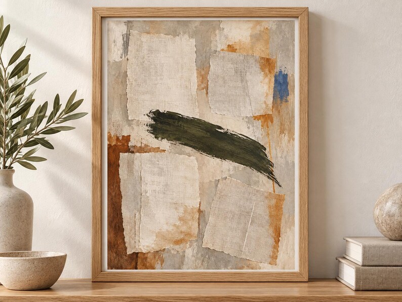 May include: A framed abstract wall art print featuring a collage of torn paper textures in shades of beige, cream, and grey, accented by a bold, horizontal dark green brushstroke and patches of burnt orange and a small spot of bright blue.