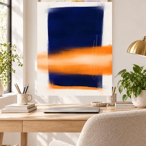 K&ouml;nnte beinhalten: Ein rechteckiger Wandkunstdruck mit einem gro&szlig;en, vertikalen marineblauen Block, der auf einem wei&szlig;en Hintergrund zentriert ist und horizontal von einem leuchtend orangefarbenen Band mit weichen, unscharfen Kanten und d&uuml;nnen, wei&szlig;en, handgezeichneten Linien durchschnitten wird.