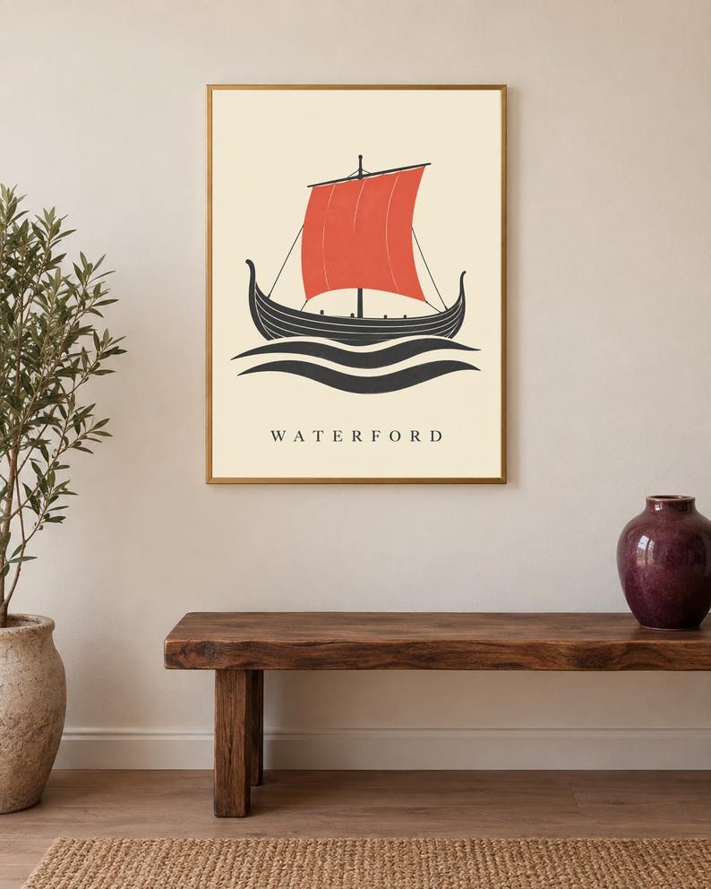 Pode incluir: Uma impress&atilde;o de arte de parede emoldurada apresentando um navio viking preto estilizado com uma vela vermelha vibrante, navegando sobre ondas pretas em um fundo creme. A palavra WATERFORD est&aacute; impressa em letras mai&uacute;sculas pretas abaixo.