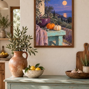 May include: A framed wall art print depicting a moonlit coastal landscape with a turquoise table holding a purple bowl, an orange pumpkin, and a white striped pumpkin, draped with a lavender cloth, all set against a backdrop of trees and water.