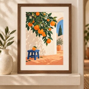 May include: A framed art print featuring an illustration of an orange tree with bright orange fruit and white blossoms hanging over a blue stool. The scene depicts a sunlit patio with a terracotta floor, a white wall, and a blue arched doorway.