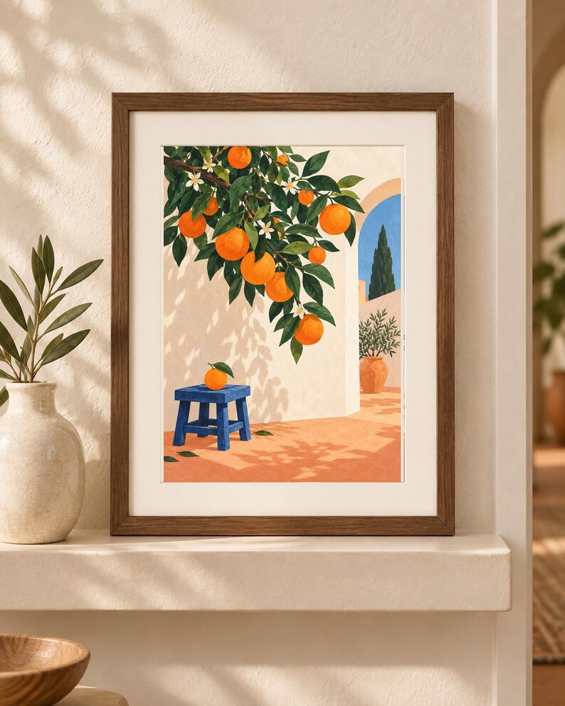 May include: A framed art print featuring an illustration of an orange tree with bright orange fruit and white blossoms hanging over a blue stool. The scene depicts a sunlit patio with a terracotta floor, a white wall, and a blue arched doorway.