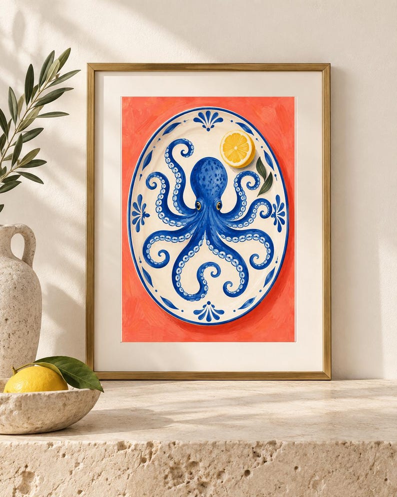 May include: A framed art print featuring a white oval platter with a blue octopus illustration and a yellow lemon slice. The platter is decorated with blue floral motifs along the rim and is set against a vibrant, solid coral-orange background.