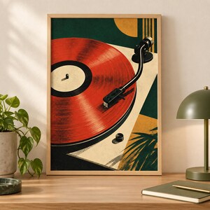 May include: A framed wall art print featuring a stylized illustration of a red vinyl record on a turntable. The composition includes geometric shapes in dark green, cream, and mustard yellow, with a black tonearm resting on the record surface.