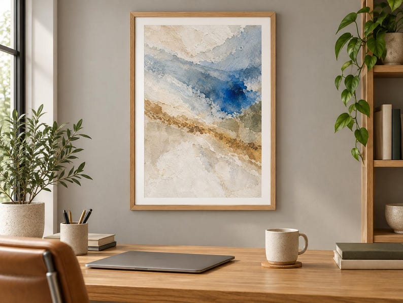 Puede incluir: Una l&aacute;mina de arte mural abstracto enmarcada con capas texturizadas en tonos crema, beige y marr&oacute;n, contrastadas por una mancha central de color azul intenso. La obra est&aacute; contenida en un marco de madera clara con una composici&oacute;n fluida.