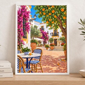 Puede incluir: Una l&aacute;mina de arte enmarcada que representa un soleado patio mediterr&aacute;neo con un edificio blanco, vibrantes buganvillas rosas, un naranjo, una fuente de piedra y una peque&ntilde;a mesa de bistr&oacute; con sillas de rayas azules y blancas en un patio.