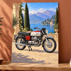May include: A rectangular wall art print featuring a vintage red and silver motorcycle parked on a stone terrace. The background displays a scenic view of a blue lake, distant mountains, and tall cypress trees under a clear, bright blue sky.