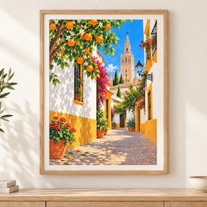 May include: A framed wall art print depicting a sunlit Mediterranean street scene with white buildings featuring yellow trim, vibrant pink bougainvillea, potted red geraniums, and an orange tree with ripe fruit under a bright blue sky.