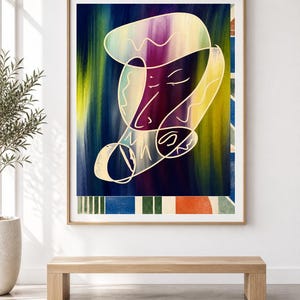 May include: A framed wall art print featuring an abstract composition with a central white line drawing of a face over a vertical gradient background of deep blue, purple, and yellow. The bottom border displays a pattern of blue, green, and orange shapes.