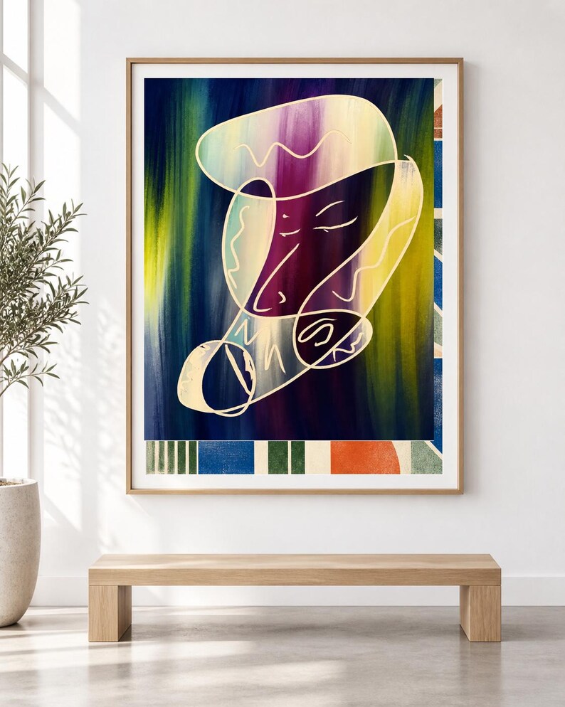 May include: A framed wall art print featuring an abstract composition with a central white line drawing of a face over a vertical gradient background of deep blue, purple, and yellow. The bottom border displays a pattern of blue, green, and orange shapes.