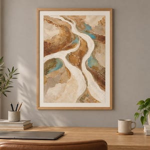 Pu&ograve; includere: Una stampa artistica da parete incorniciata raffigurante un dipinto di paesaggio aereo astratto con sentieri bianchi fluidi simili a fiumi, toni della terra marroni e marrone chiaro strutturati e piccole macchie di acqua blu verde.