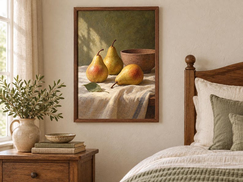 May include: A framed wall art print depicting a still life scene with three yellow and red pears and a brown bowl resting on a textured white cloth. The painting features a dark green background and is displayed in a simple wooden frame.